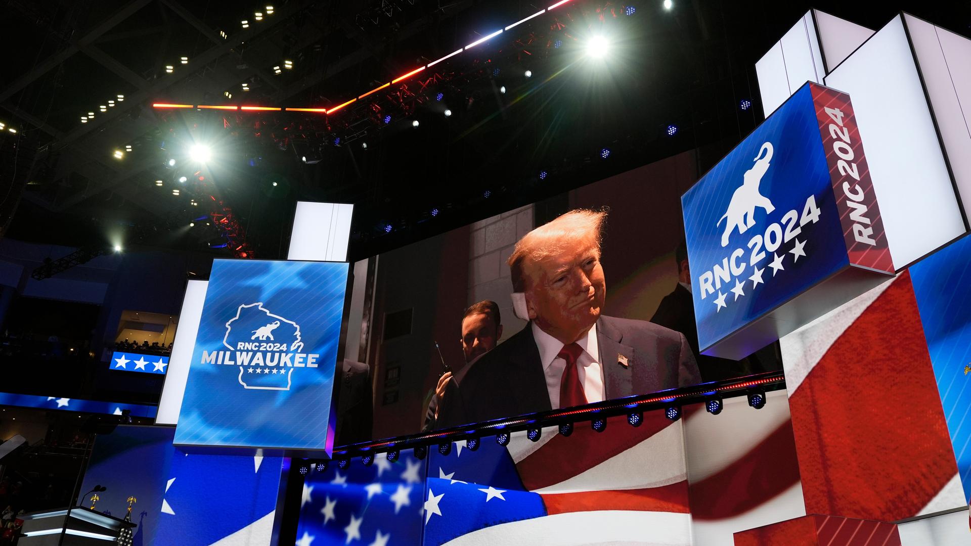 Eine große Videoleinwand zeigt Donald Trump beim Parteitag der US-Republikaner . Sein Ohr hat er mit einem großen weißen Pflaster bandagiert.