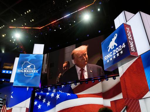 Eine große Videoleinwand zeigt Donald Trump beim Parteitag der US-Republikaner . Sein Ohr hat er mit einem großen weißen Pflaster bandagiert.
