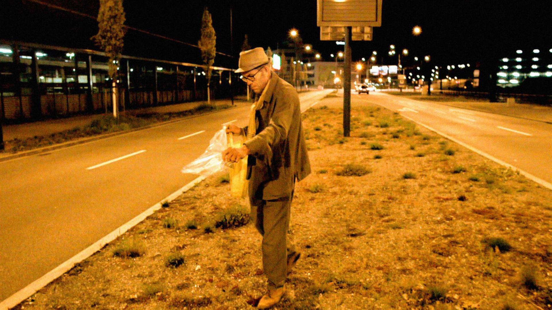 Der Zürcher Guerilla Gardener und Koch Maurice Maggi verstreut Samen auf dem Mittelstreifen einer Straße, Aufnahme aus dem Film Wild Plants.