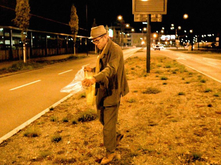 Der Zürcher Guerilla Gardener und Koch Maurice Maggi verstreut Samen auf dem Mittelstreifen einer Straße, Aufnahme aus dem Film Wild Plants.