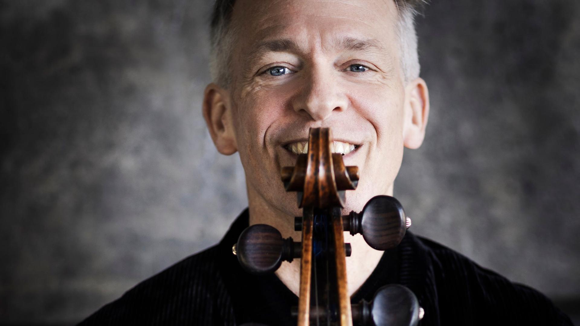 Alban Gerhardt lacht über die Schmecke seines Cellos hinweg, die er direkt vor sein Gesicht hält. Alban Gerhardt lacht über die Schmecke seines Cellos hinweg, die er direkt vor sein Gesicht hält.