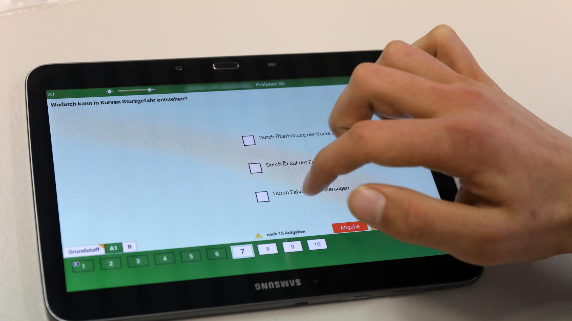 Bei einer theoretischen Führerscheinprüfung bei der DEKRA beantwortet ein Prüfling auf dem Tablet eine Frage.