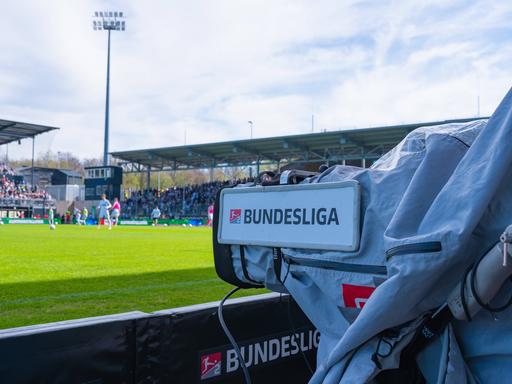Eine Fernsehkamera mit der Aufschrift "Bundesliga" filmt das Spielgeschehen.