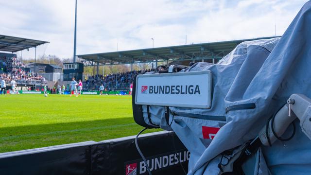Eine Fernsehkamera mit der Aufschrift "Bundesliga" filmt das Spielgeschehen.