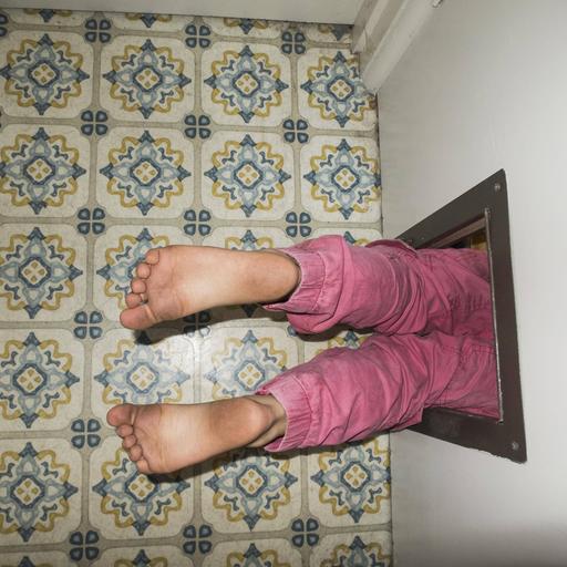 Kinderbeine die aus einer Türöffnung herausschauen.