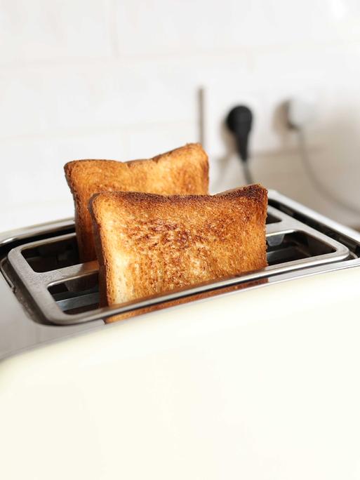 Ein weißer Toaster mit zwei gebackenen Scheiben Toast.