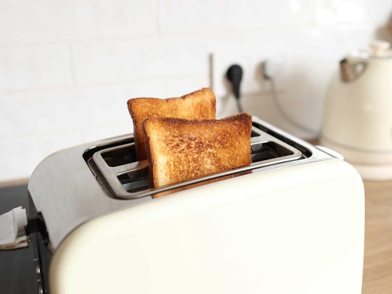 Ein weißer Toaster mit zwei gebackenen Scheiben Toast.