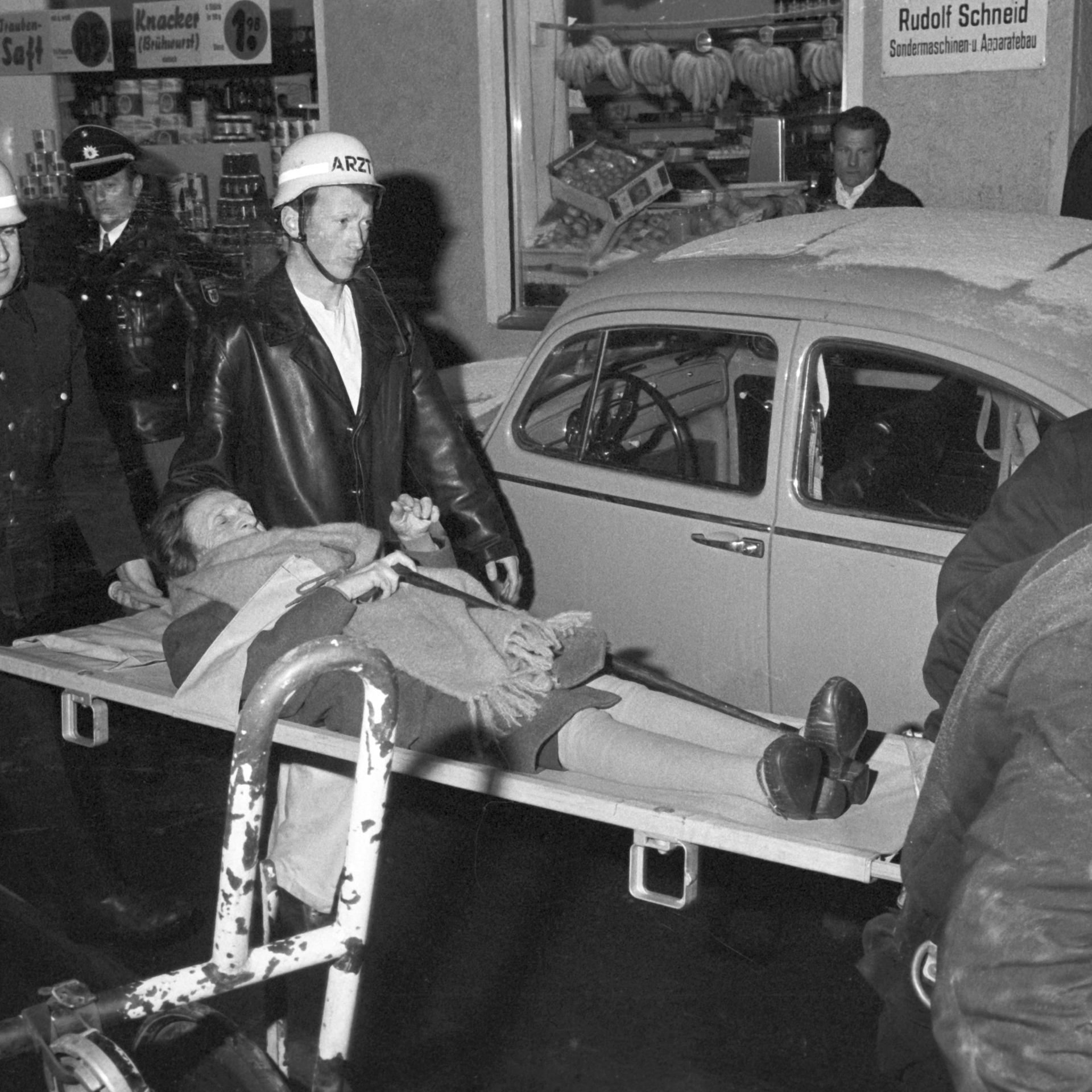 12.02.1970, Bayern, München: Eine Bewohnerin des Altenheims wird mit einer Rauchvergiftung ins Krankenhaus transportiert. 