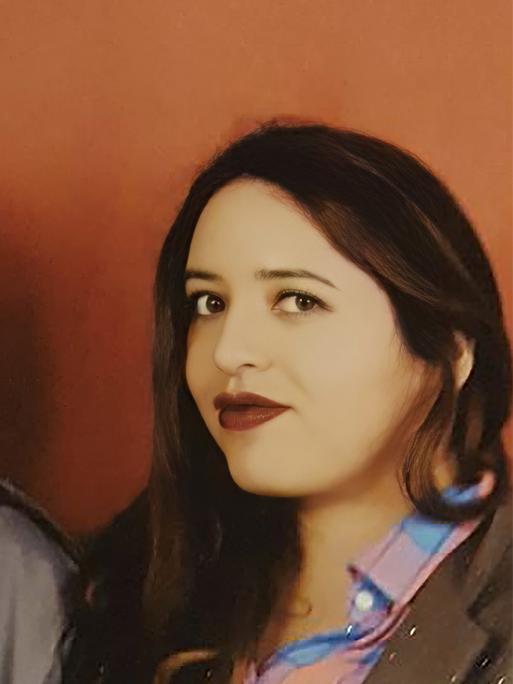 Porträt einer Frau mit ihrem Sohn vor einer orangefarbenen Wand