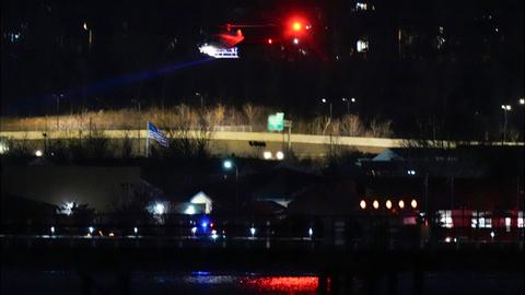 Ein Hubschrauber fliegt mit seinem Suchscheinwerfer in der Dunkelheit über den Fluss Potomac.