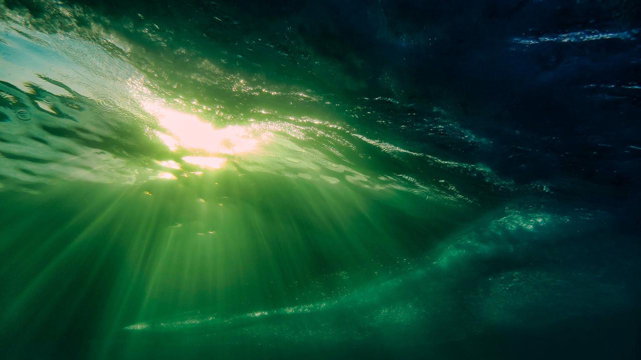 Sonnenstrahlen scheinen durch eine Wasseroberfläche.