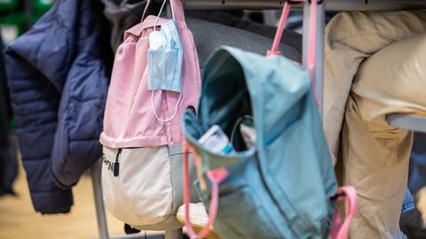 In der 9. Klasse der Gesamtschule in Münster hängt an einem Klassentisch neben einem Rucksack eine Mund- Nasenbedeckung.
