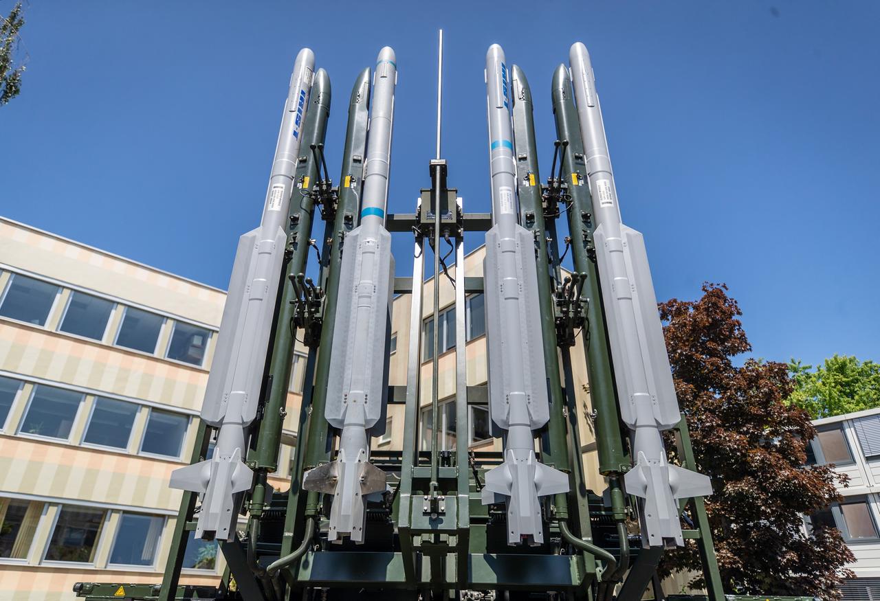 Ein Raketenabwehrsystem vom Typ Iris-T steht auf einem Firmengelände. Vier der Abwehrraketen sind nebeneinander an einer Art Gerüst befestigt.
