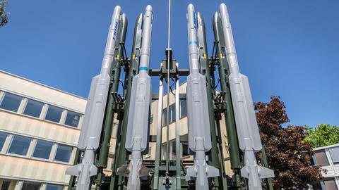 Ein Raketenabwehrsystem vom Typ Iris-T steht auf einem Firmengelände. Vier der Abwehrraketen sind nebeneinander an einer Art Gerüst befestigt.