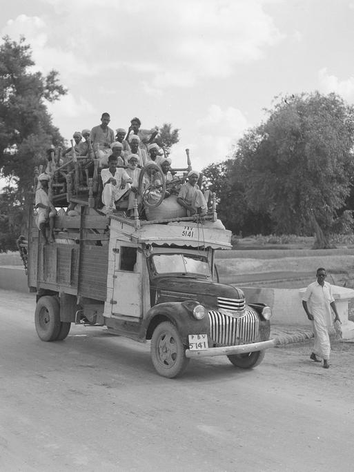 Historisches Schwarzweißfoto von 1947: Flüchtlinge sitzen auf einem mit Möbeln beladenen LKW.