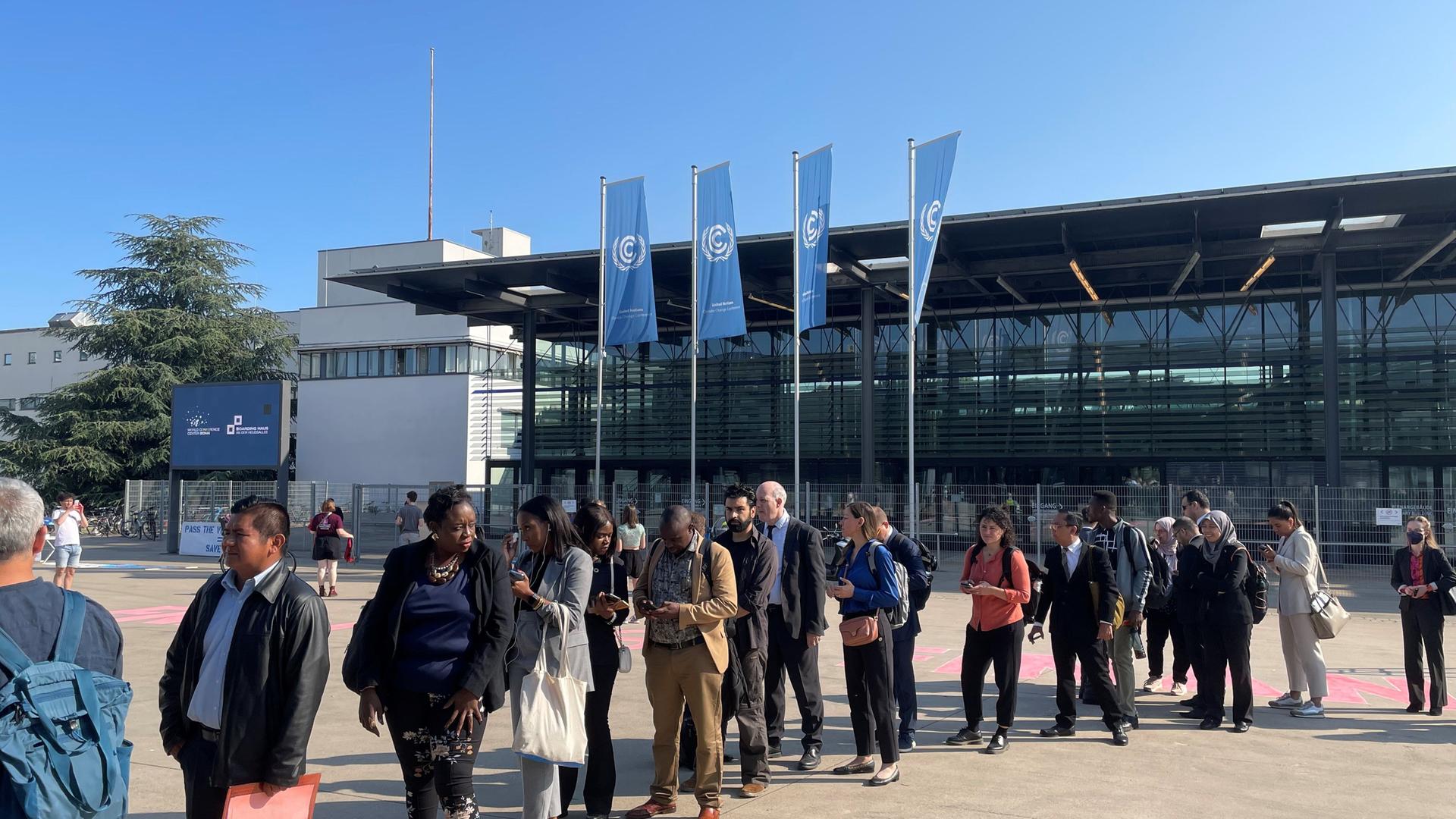 Nordrhein-Westfalen, Bonn: Delegierte der UN-Klimakonferenz warten am Montagmorgen vor dem World Conference Center in Bonn. Die zehntägige Konferenz in Bonn dient der Vorbereitung der Weltklimakonferenz (COP28) Ende des Jahres in Dubai.