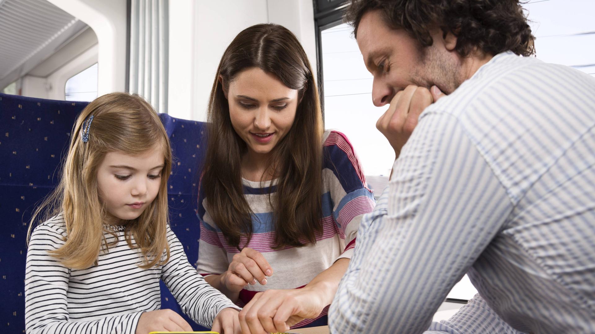 Eine Familie spielt Karten an einem Tisch in einem Abteil von der Deutschen Bahn. Eine Familie spielt Karten an einem Tisch in einem Abteil von der Deutschen Bahn.