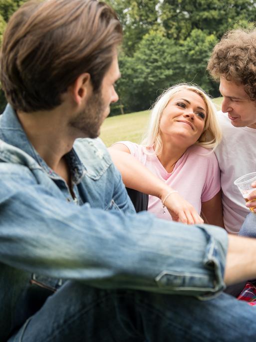 Ein Mann beobachtet ein glückliches Pärchen im Park.