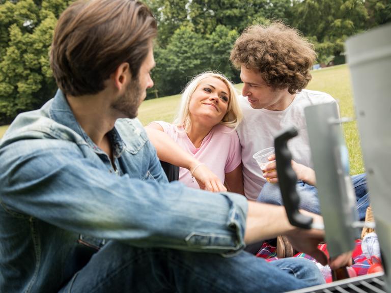 Ein Mann beobachtet ein glückliches Pärchen im Park.