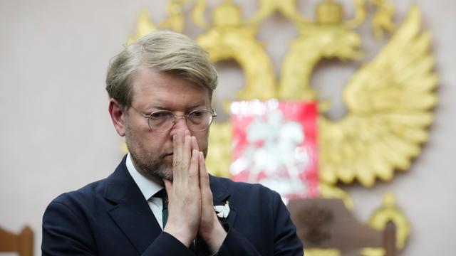 Das Bild zeigt Rybakow vor Gericht. Er hält seine Hände flach aneinandergelegt vor dem Mund. Im Hintergrund ist das russische Staatswappen zu erkennen.