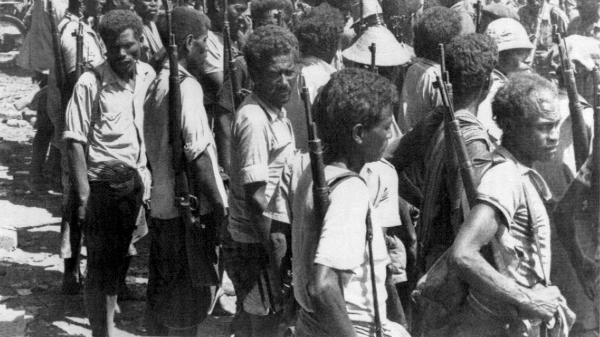 Schwarzweiß-Aufnahme bewaffneter Anhänger der Unabhängigkeitsbewegung UDT (Demokratische Union Timors) im August 1975 in der Hauptstadt Dili. Schwarzweiß-Aufnahme bewaffneter Anhänger der Unabhängigkeitsbewegung UDT (Demokratische Union Timors) im August 1975 in der Hauptstadt Dili.