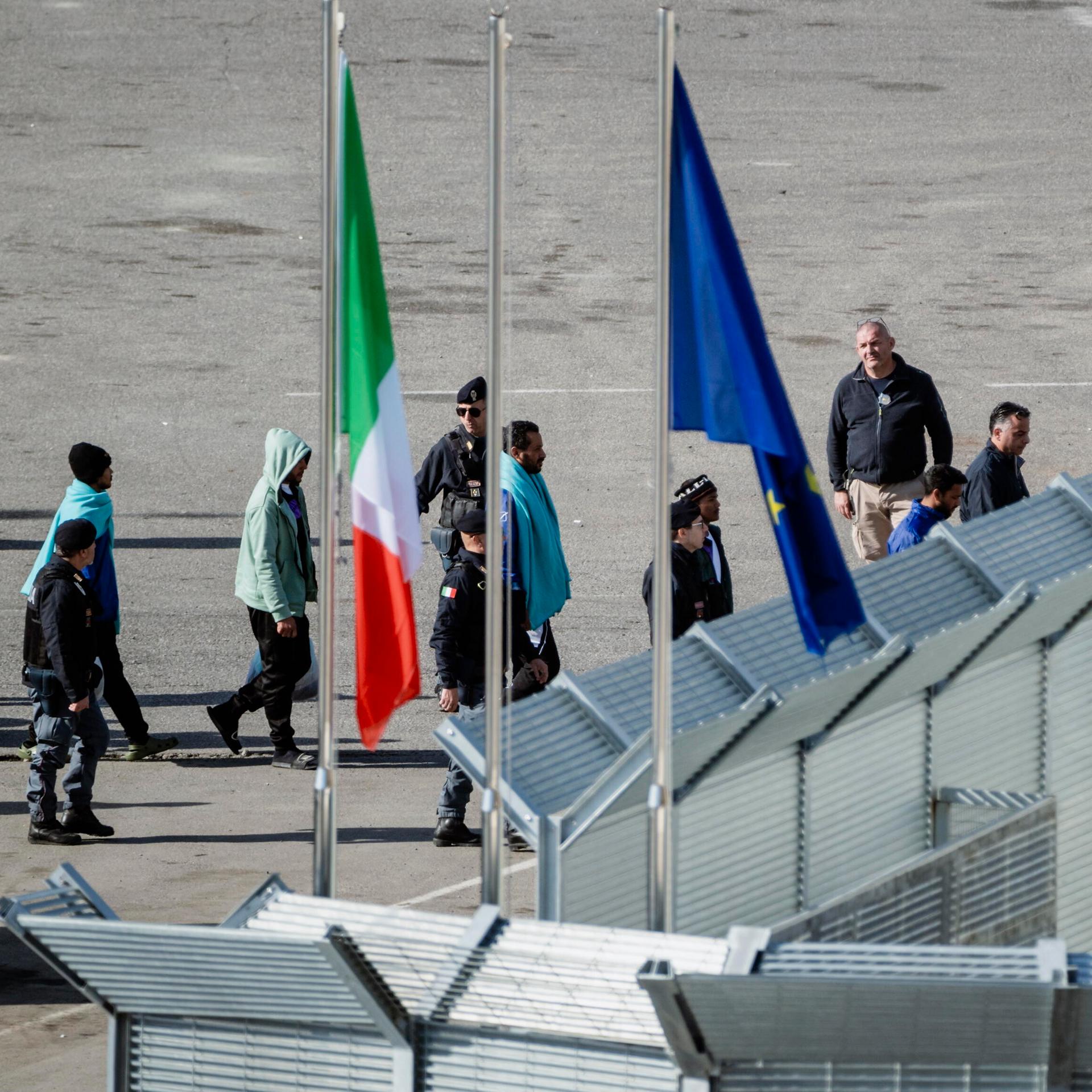 Migranten aus verschiedenen Herkunftsländern kommen im Albanischen Hafen Shengin an