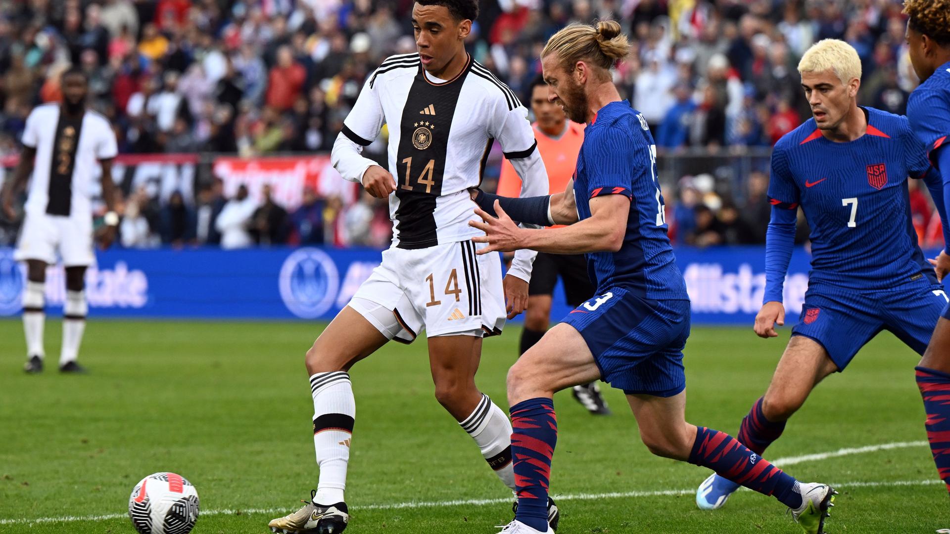 Deutschlands Jamal Musiala (l) und Tim Ream von den USA kämpfen um den Ball.