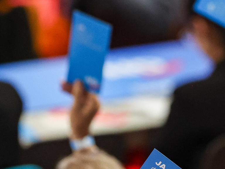 AfD-Stimmkarte mit der Aufschrift "Ja" wird hochgehalten