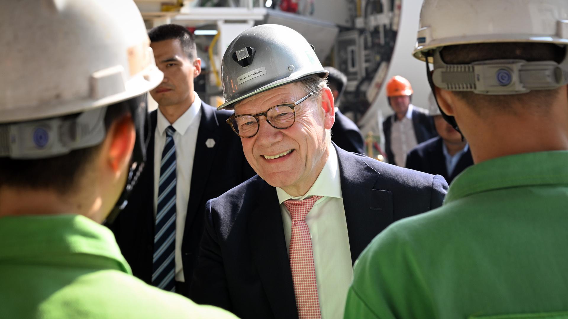 Guangdong: Bundesaußenminister Wadephul (M, CDU) besucht die Herrenknecht AG. Zwei Mitarbeiter sind stehen vor ihm und sind von hinten zu sehen. Guangdong: Bundesaußenminister Wadephul (M, CDU) besucht die Herrenknecht AG. Zwei Mitarbeiter sind stehen vor ihm und sind von hinten zu sehen.
