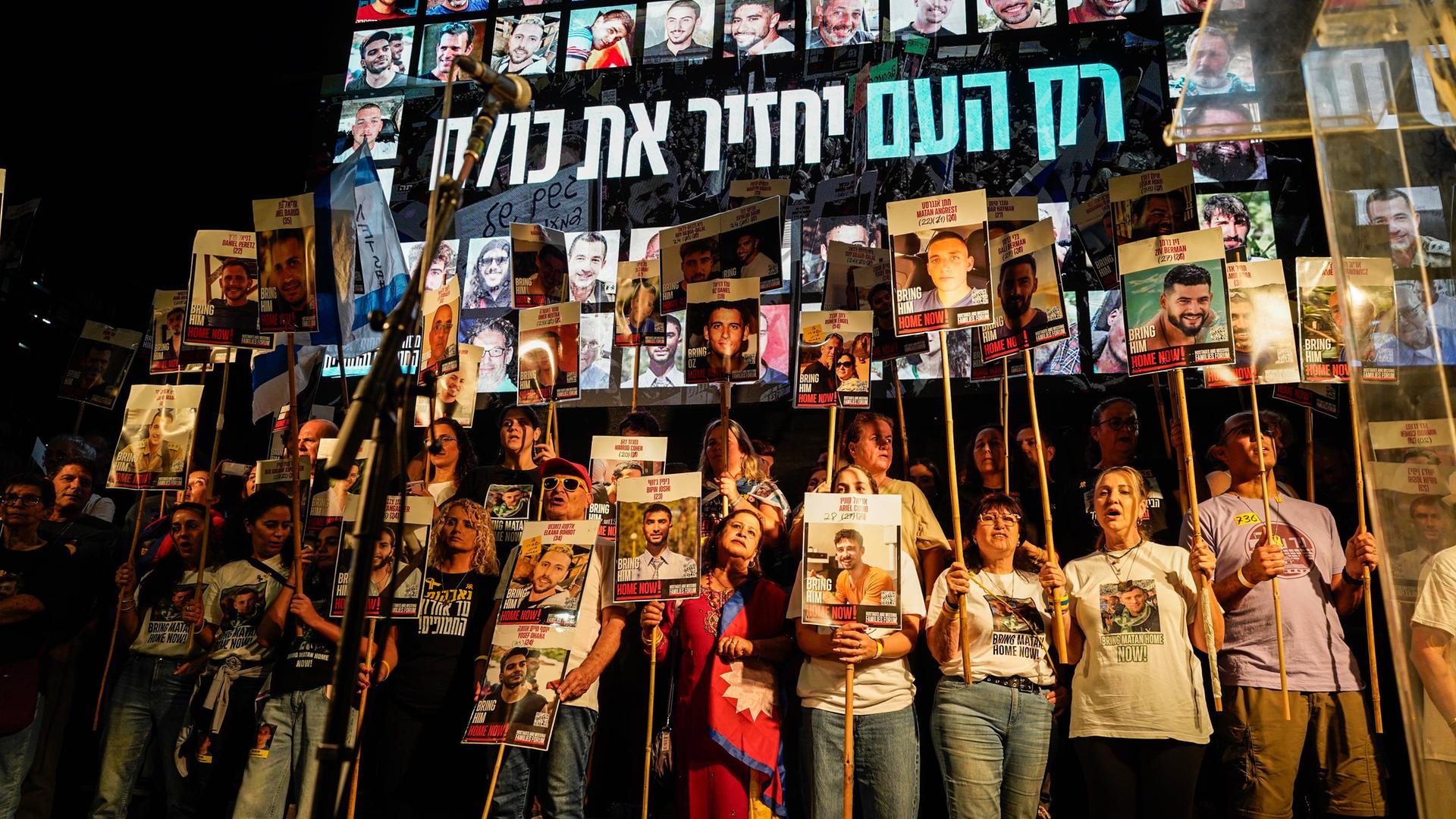 Familienangehörige der Hamas-Geiseln stehen auf einer Bühne während einer Demonstration in Tel Aviv.