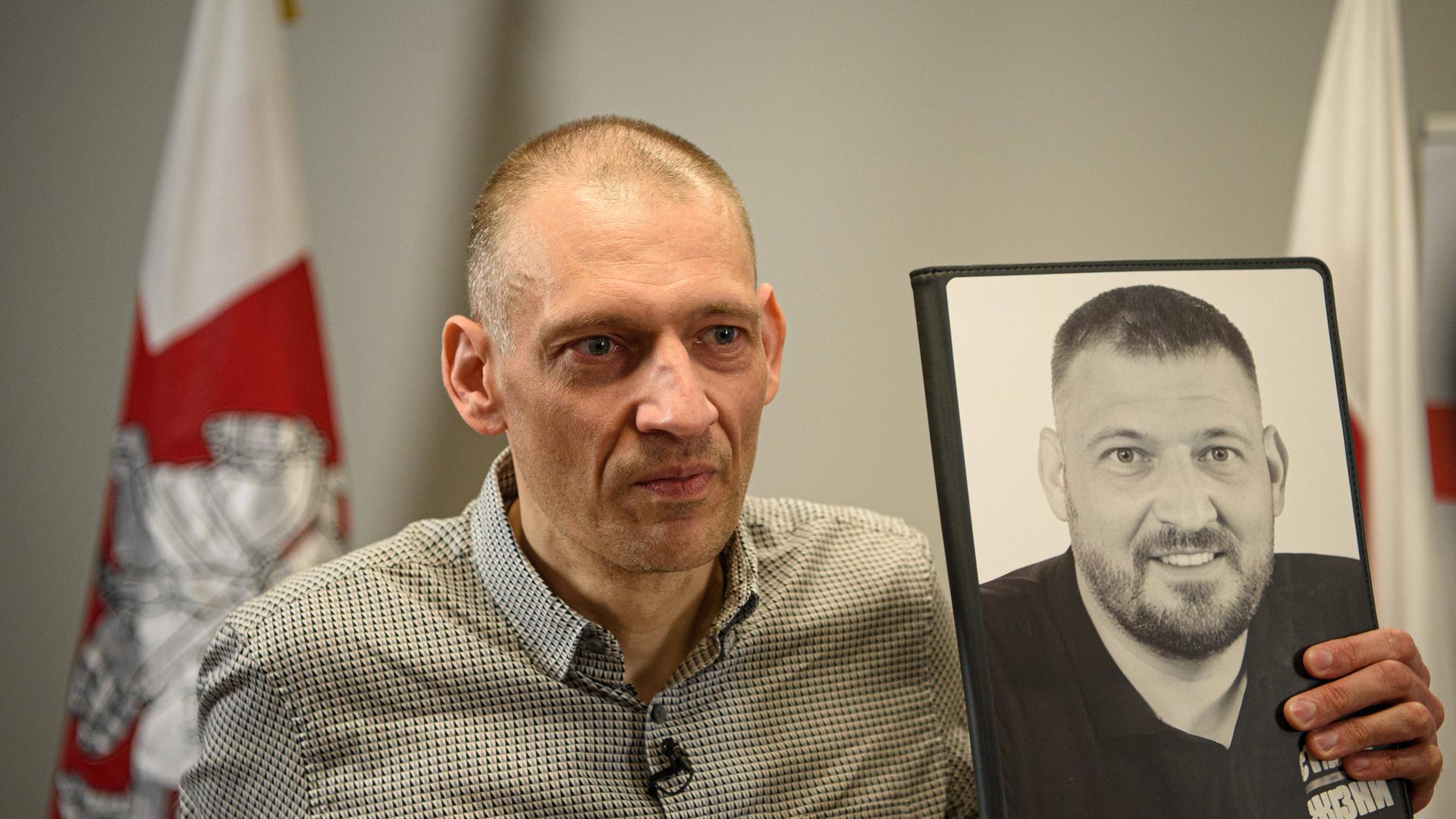 Der ausgemergelte belarussische Oppositionelle Sergej Tichanowski hält ein Foto, das ihn vor seiner Inhaftierung in Belarus zeigt. Der ausgemergelte belarussische Oppositionelle Sergej Tichanowski hält ein Foto, das ihn vor seiner Inhaftierung in Belarus zeigt.