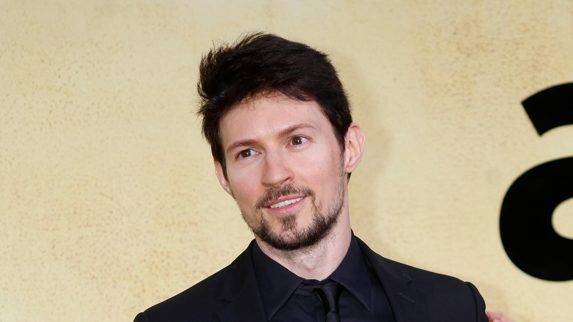 Pawel Durow steht vor hellem Hintergrund und lächelt. 