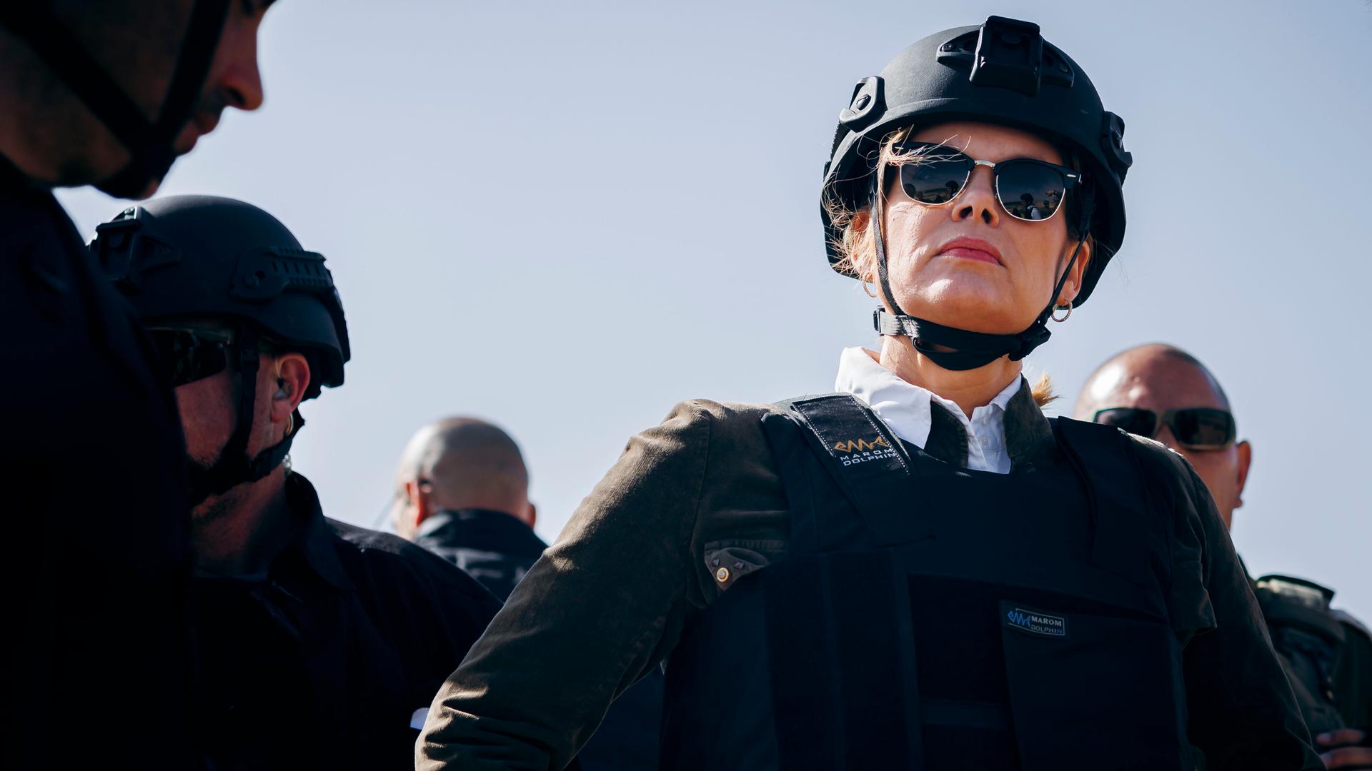 Das Bild zeigt Julia Klöckner in Schutzkleidung mit Helm und schusssicherer Weste. Umringt wird sie von Soldaten.