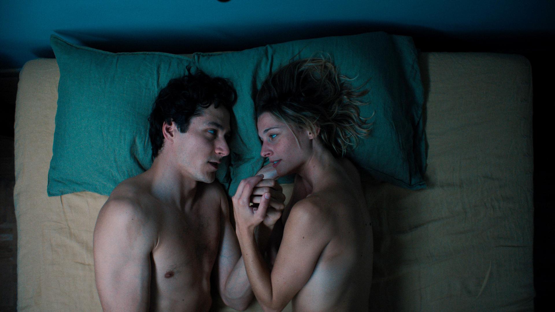Filmszene zeigt einen Mann und eine Frau im Bett. Luis (Noah Saavedra) und Marie (Svenja Jung) reden das erste mal über sich selbst. Aus der Folge 1 "Der Sex", Regie Bettina Oberli.