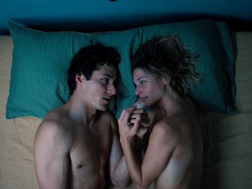 Filmszene zeigt einen Mann und eine Frau im Bett. Luis (Noah Saavedra) und Marie (Svenja Jung) reden das erste mal über sich selbst. Aus der Folge 1 "Der Sex", Regie Bettina Oberli.
