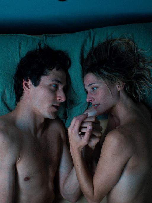 Filmszene zeigt einen Mann und eine Frau im Bett. Luis (Noah Saavedra) und Marie (Svenja Jung) reden das erste mal über sich selbst. Aus der Folge 1 "Der Sex", Regie Bettina Oberli.