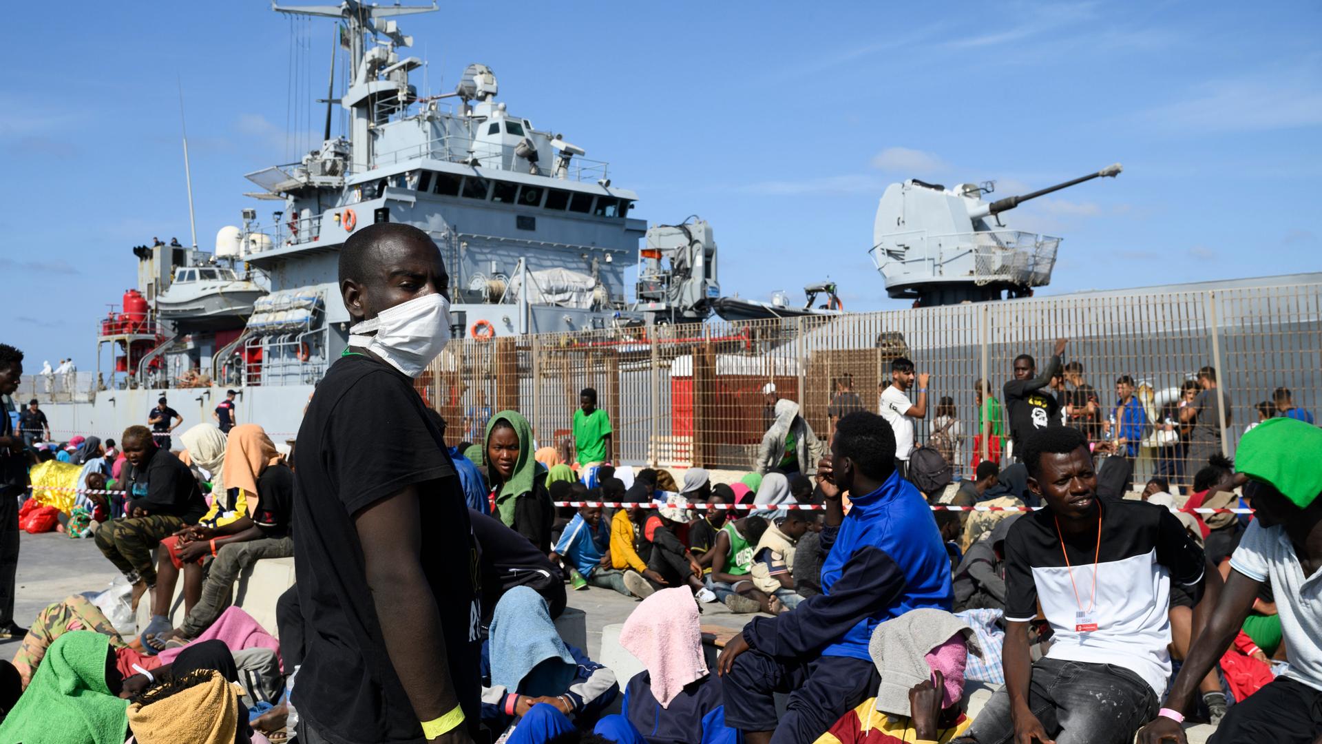 Geflüchtete warten darauf, von der Insel Lampedusa auf das Festland gebracht zu werden.