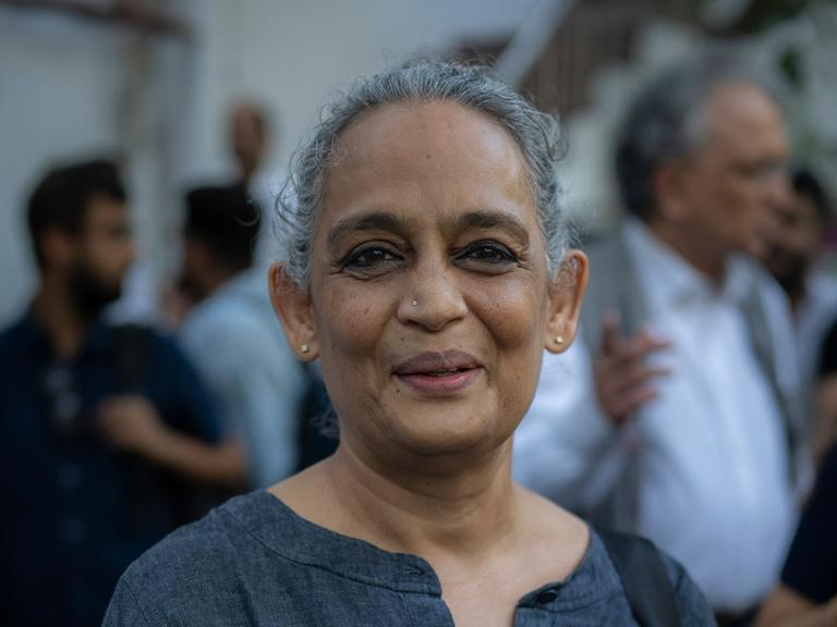 Die indische Schriftstellerin Arundhati Roy nimmt an einem Protest des indischen Presseclubs in Neudelhi teil. Sie trägt ein graues Kleid und hat ein Schild um den Hals auf dem Steht "Free The Press".