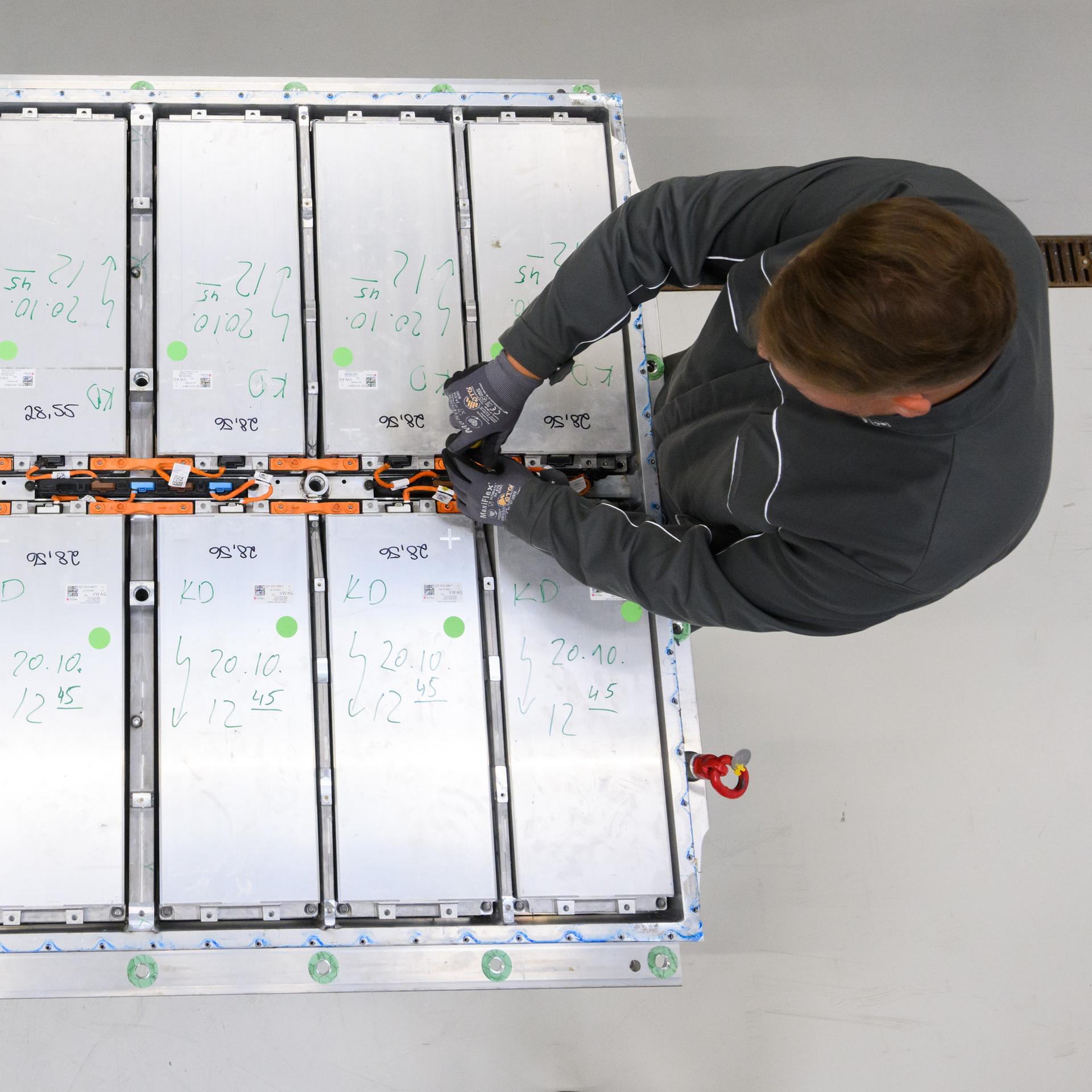 Ein Mitarbeiter entnimmt Batteriemodule aus einer ausgedienten Batterie eines Elektroautos im Batterie-Recycling des VW-Werks Salzgitter. 

