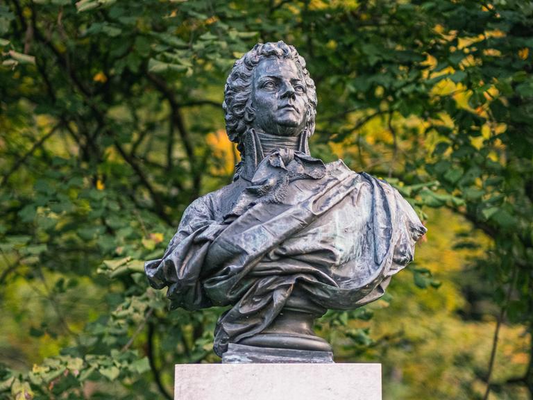 Wir sehen eine Büste des Komponisten Wolfgang Amadeus Mozart. 