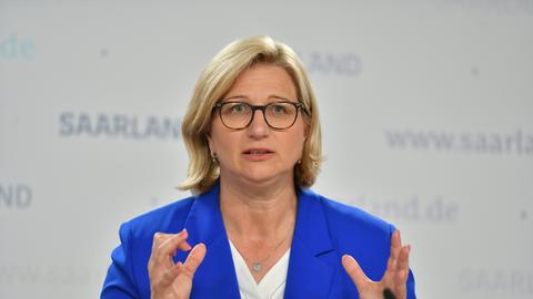 Saarlands Ministerpräsidentin Anke Rehlinger (SPD) spricht bei einer Pressekonferenz, hinter ihr ist der Schriftzug Saarland zu sehen.