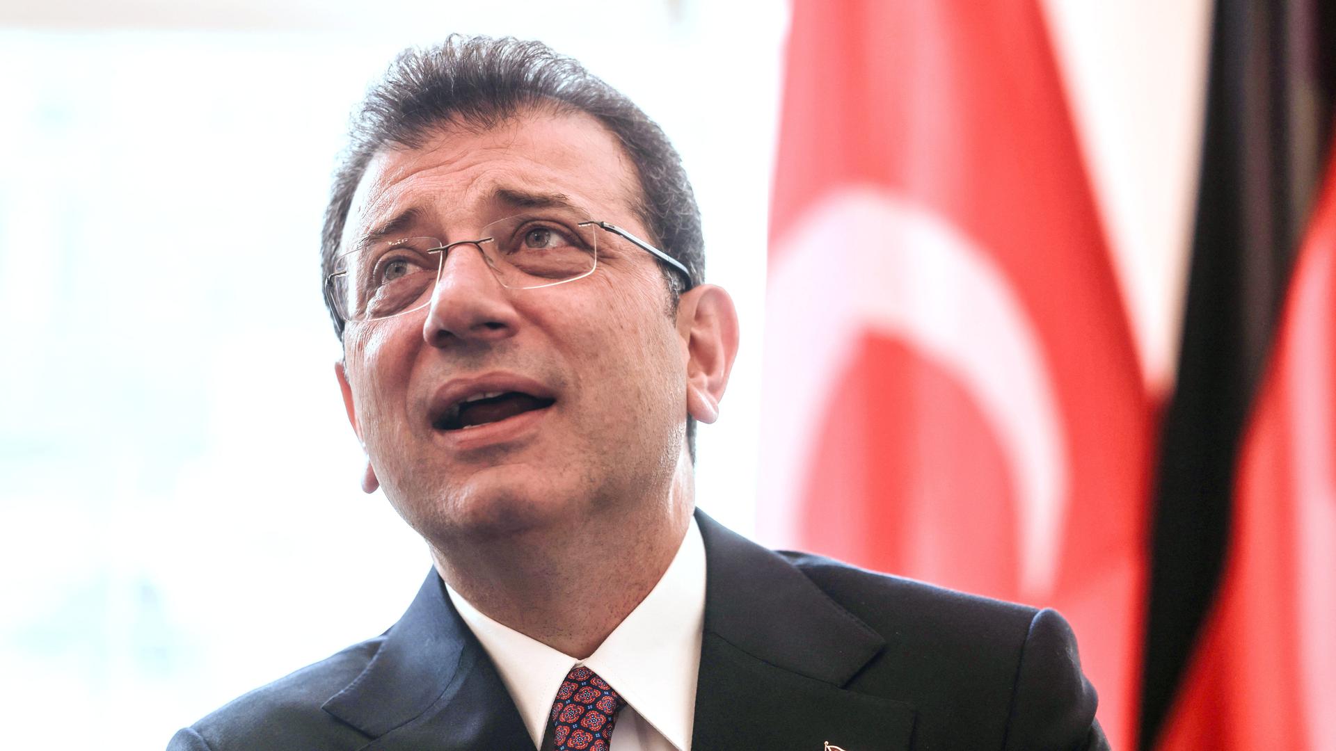 Das Foto zeigt Ekrem Imamoglu vor einer türkischen Fahne.