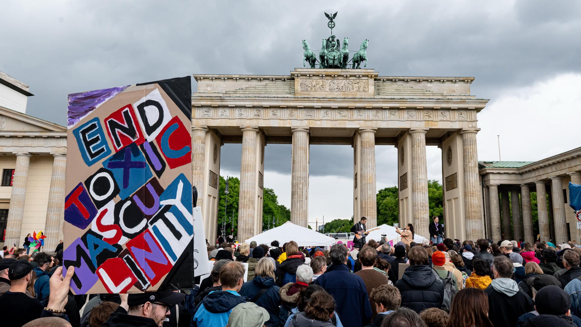Menschen nehmen an der Demonstration "Männer gegen Gewalt" teil. Im Vordergrund ein Schild mit der Aufschrift "end toxic masculinity", im Huintergrund das Brandenburger Tor. Menschen nehmen an der Demonstration "Männer gegen Gewalt" teil. Im Vordergrund ein Schild mit der Aufschrift "end toxic masculinity", im Huintergrund das Brandenburger Tor.