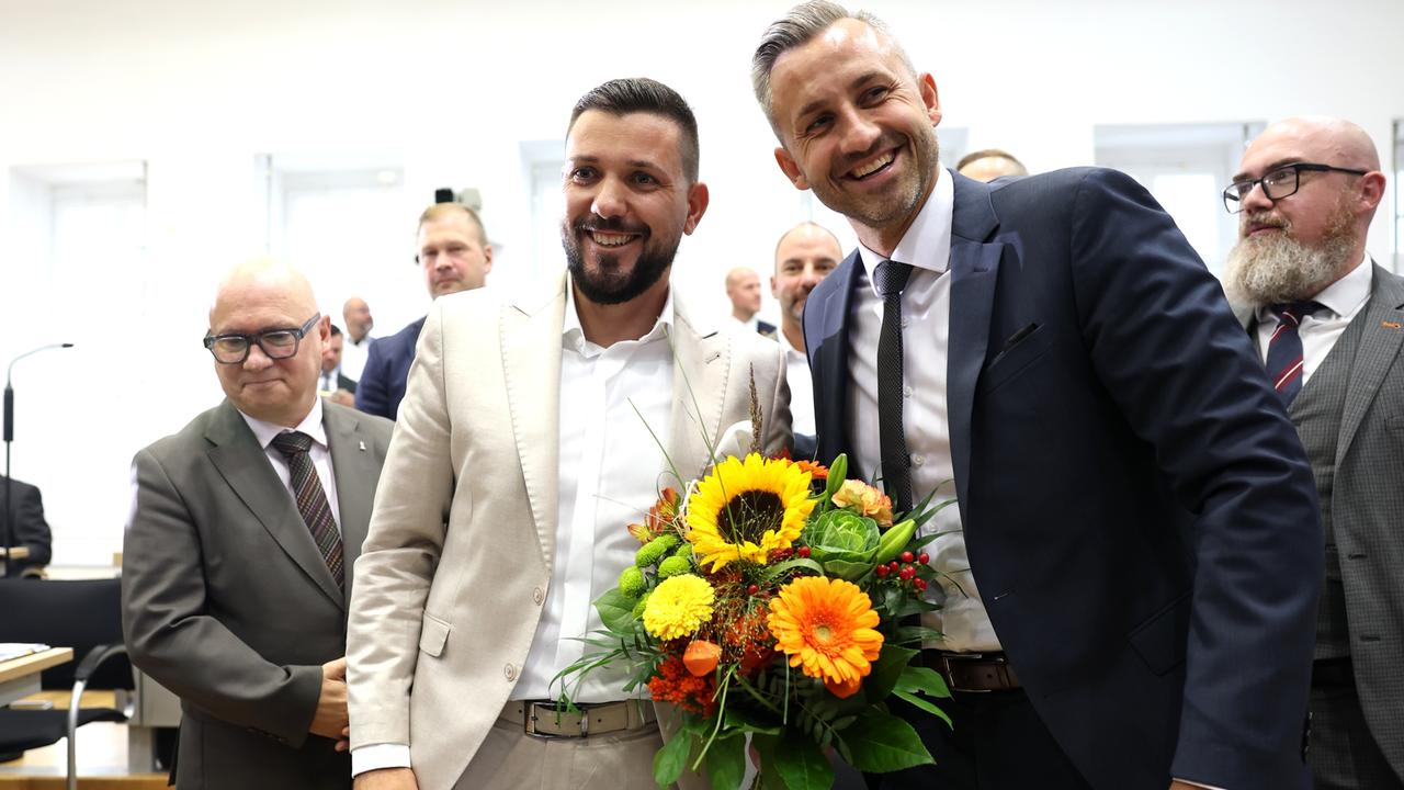 AfD-Spitzenvertreter gratulieren Tobias Rausch zur Wahl zum Landtagspräsidenten während der konstituierenden Sitzung des Landtags von Sachsen-Anhalt. Rausch und Siegmund (Mitte) halten einen gelben Blumenstrauß.