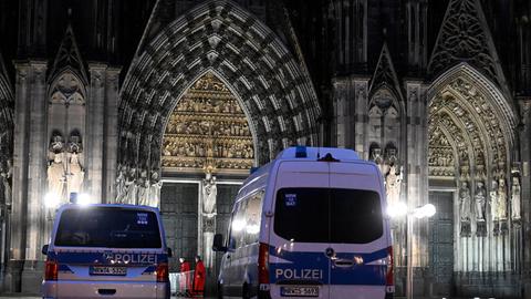 Polizeifahrzeuge stehen vor dem Kölner Dom.