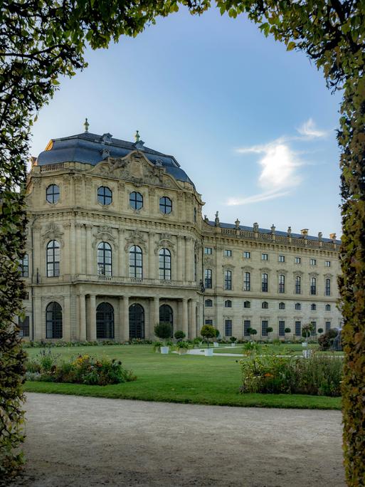 Blick durch einen Rosenbogen auf die Garten-Schlossseite der Würzburger Residenz.