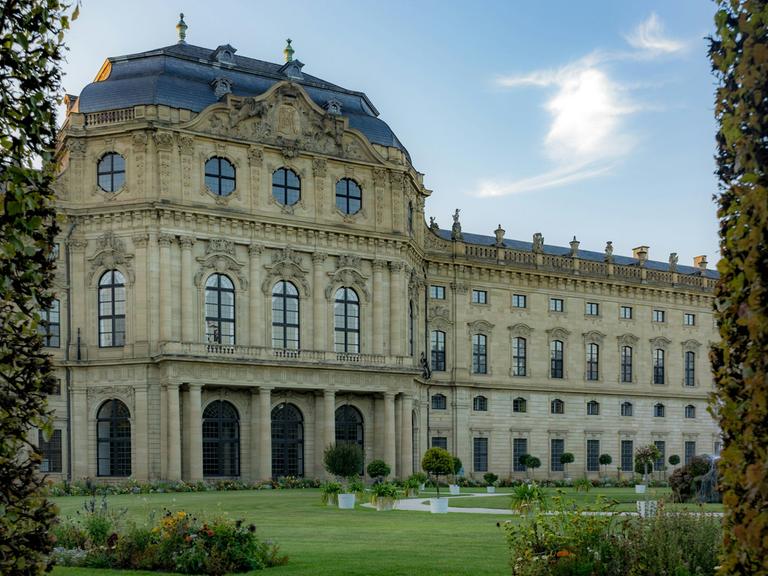 Blick durch einen Rosenbogen auf die Garten-Schlossseite der Würzburger Residenz.