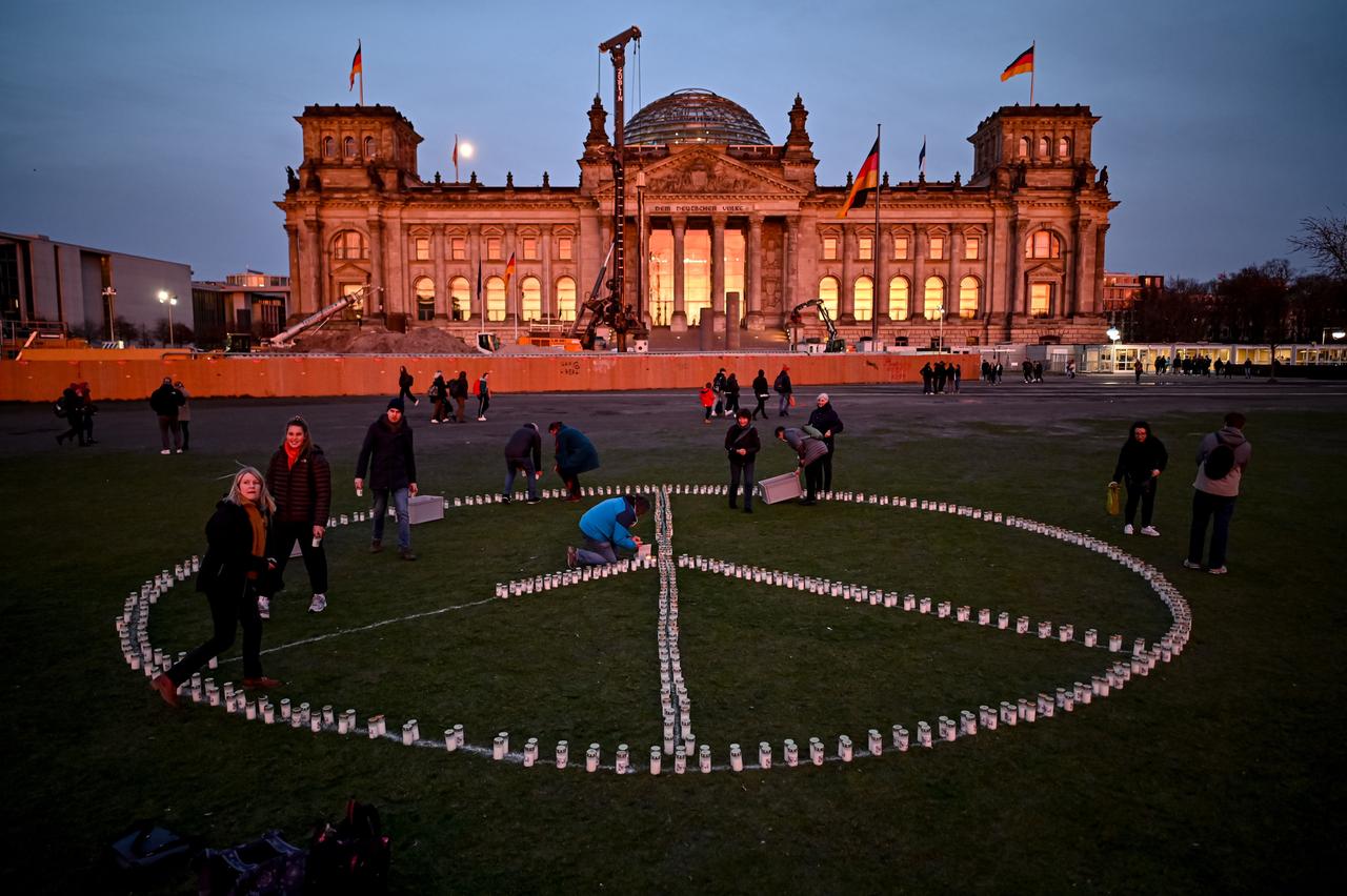 Vor dem Reichtagsgebäude haben Menschen Kerzen abgelegt. Sie bilden das Friedenssymbol. Vor dem Reichtagsgebäude haben Menschen Kerzen abgelegt. Sie bilden das Friedenssymbol.