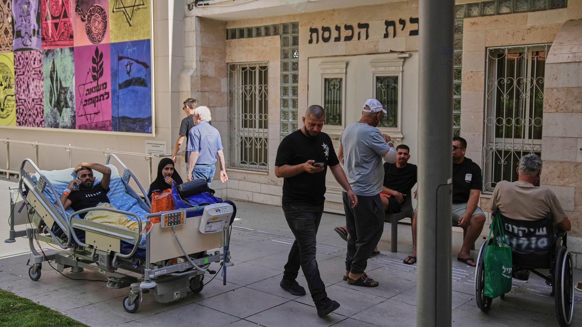 Patienten des Soroka-Krankenhauses im israelischen Be'er Sheva warten im Freien, nachdem das Gebäude von einer aus dem Iran abgefeuerten Rakete getroffen wurde. Patienten des Soroka-Krankenhauses im israelischen Be'er Sheva warten im Freien, nachdem das Gebäude von einer aus dem Iran abgefeuerten Rakete getroffen wurde.