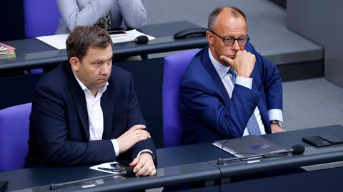 Bundesfinanzminister Lars Klingbeil SPD und Bundeskanzler Friedrich Merz CDU sitzen im Deutschen Bundestages im Reichstagsgebäude in Berlin und schauen nachdenklich